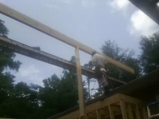 Carpenter setting a ridge beam over a new addition frame — Ice Dam Removal by Roofing Brothers in Burlingham