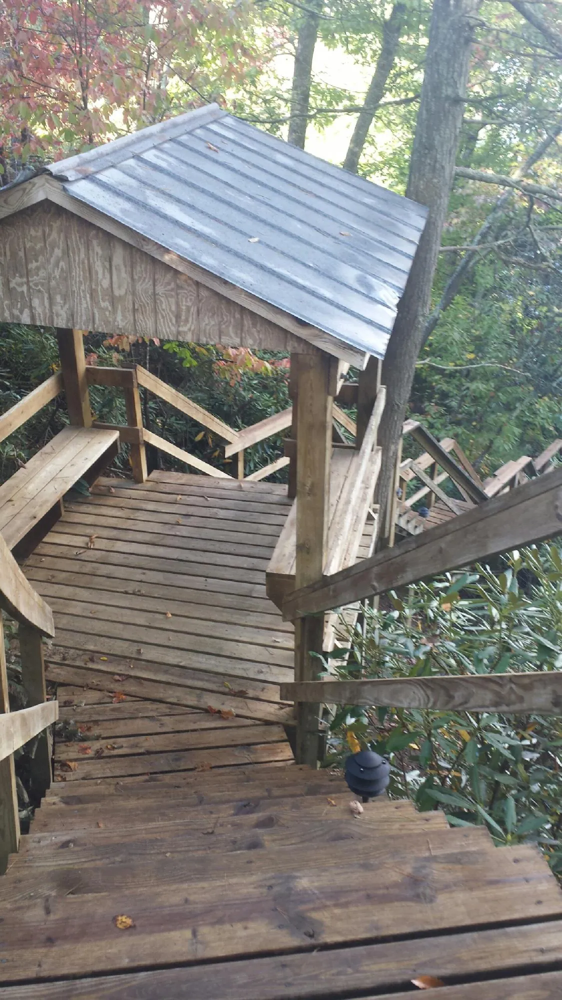 Metal roofed shelter over wooden steps on a wooded walkway — Skylight Repair & Installation work by our crew in Burlingham
