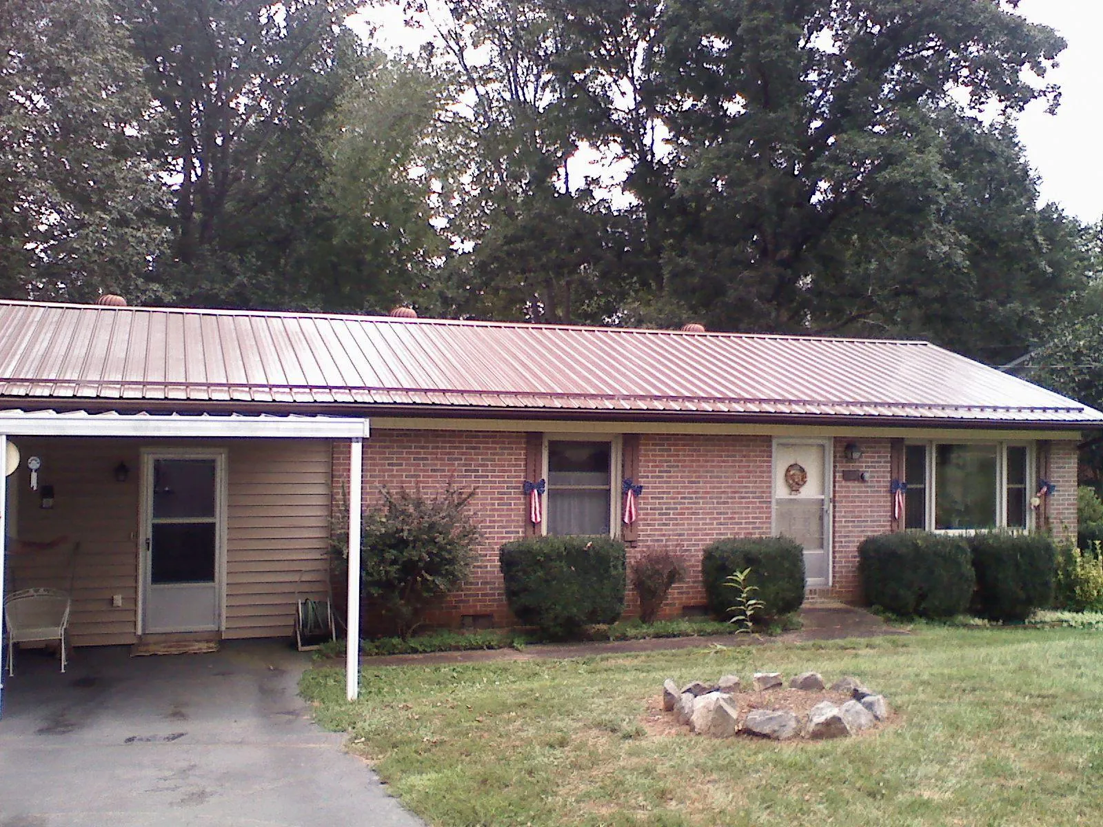 Bronze metal roof and carport on a brick ranch home — Roof Repair work by our crew in Burlingham